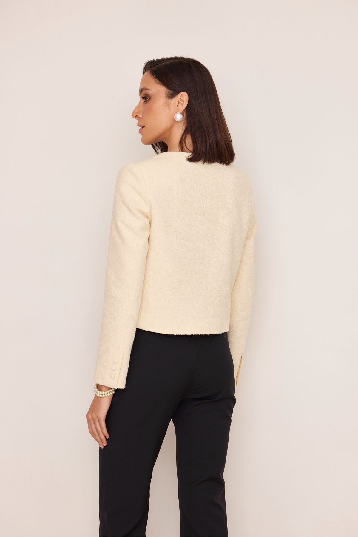 Short bouclé jacket with buttons made of cream fabric