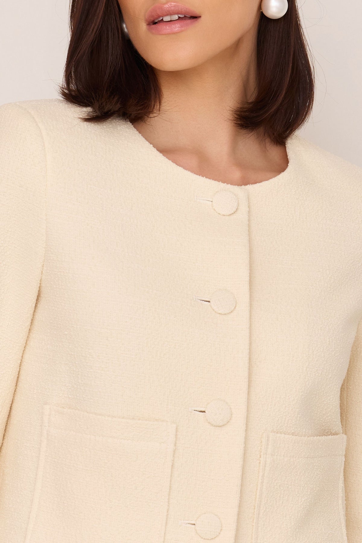Short bouclé jacket with buttons made of cream fabric